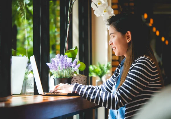 Blogger Asian Women\'s writers are using laptops at the coffee shop to write, share stories or travel reviews to her social media followers in travel concept , vintage style