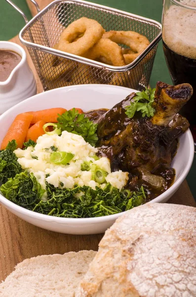 Lamb Shank Dinner.Traditional St Patricks Day Lamb Shank served with Colcannon, Stout battered onion rings and a glass of Irish Stout.