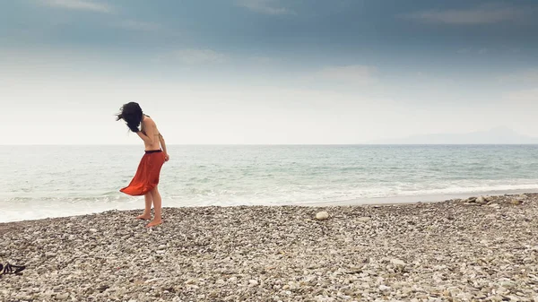 Jovem mulher caminhando sozinha descalça na costa — Fotografia de Stock