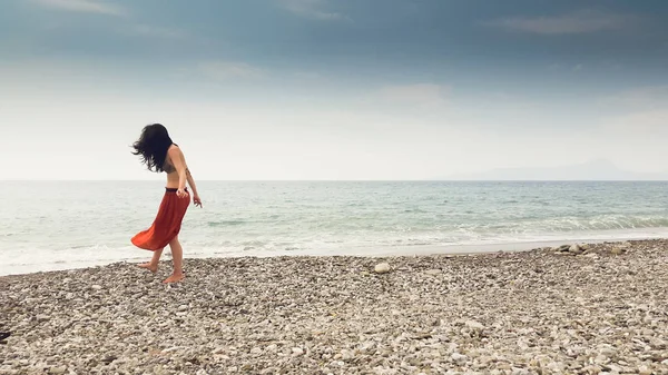 Young woman walking alone in barefoot at the shore — Stock Photo, Image