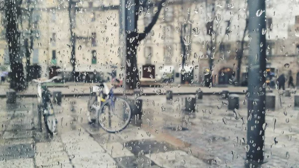 Raining in the city of Turin with drops on glass