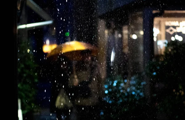Deszczowa noc pieszych ludzi z parasolem — Zdjęcie stockowe