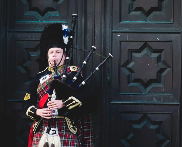 Hombre escocés vestido con ropa tradicional y jugando gaitas Imagen de stock