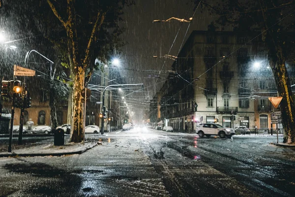 Зимняя улица в городе ночью с дождем и снегом — стоковое фото