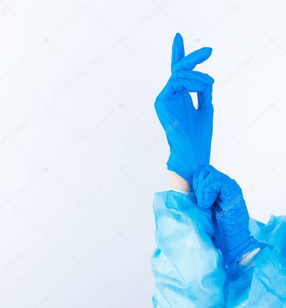 one hand pulls a medical glove on the other hand on a white background