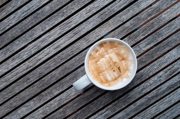 Xícara de café Macchiato caramelo quente em fundo de madeira — Fotografia de Stock