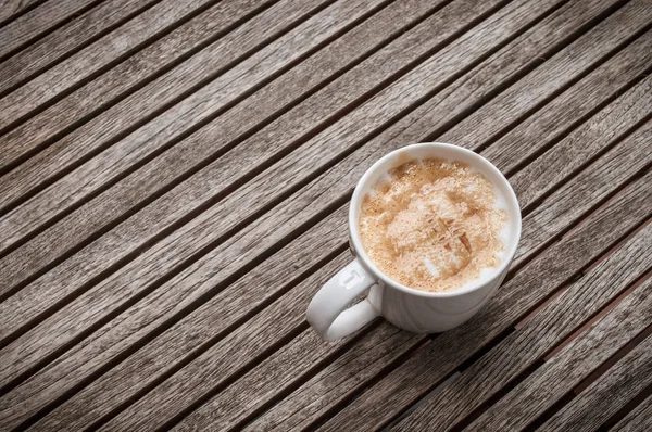 Tasse heißen Karamell-Macchiato-Kaffee auf Holzgrund — Stockfoto