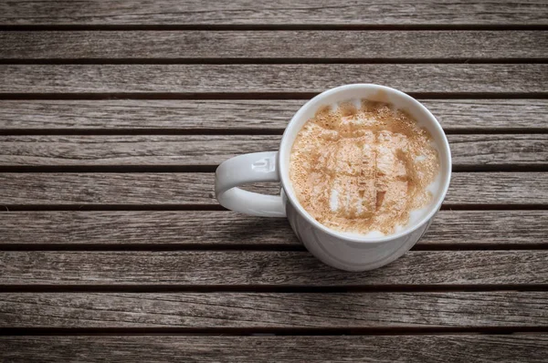 Tom vintage para xícara de café Macchiato caramelo quente em banco de madeira — Fotografia de Stock