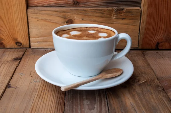 Tasse de café Latte Art chaud en fond de bois — Photo