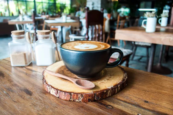 Café caliente lindo del cappuccino en platillo de madera en la cafetería —  Fotos de Stock