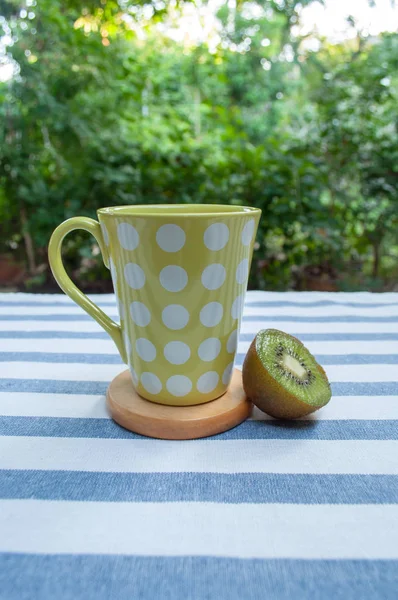 Polka-Dot Cup of Coffee e Kiwi na tabela de padrões de linha no Jardim — Fotografia de Stock