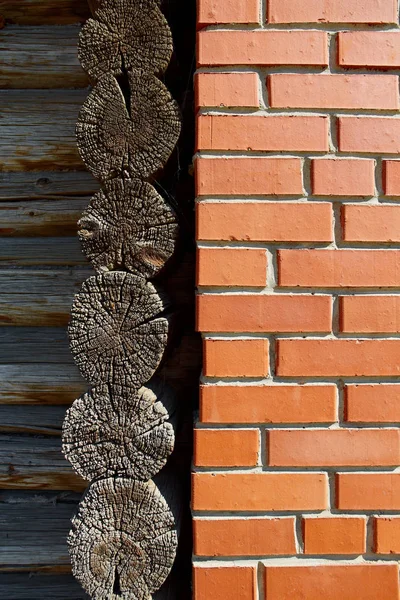 La pared de una antigua casa de madera y ladrillo nuevo. El concepto de un cambio de generaciones, nuevo, progresivo. Preservación de lo viejo, la memoria de la cultura y las tradiciones. Construcción en el pueblo —  Fotos de Stock