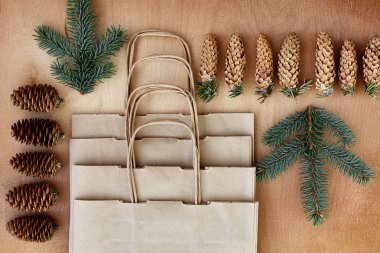 Çam kozalakları ve Kraft torba ahşap arka plan üzerinde. Noel hediyeleri el yapımı oluşturma kavramı