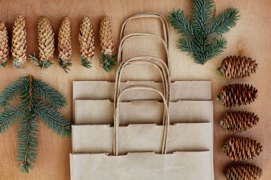 Çam kozalakları ve Kraft torba ahşap arka plan üzerinde. Noel hediyeleri el yapımı oluşturma kavramı