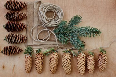 Çam kozalakları ve Kraft kağıt ahşap arka plan üzerinde. Noel hediyeleri el yapımı oluşturma kavramı