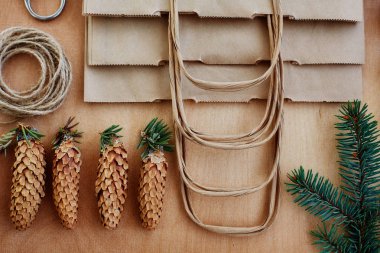 Çam kozalakları ve Kraft kağıt ahşap arka plan üzerinde. Noel hediyeleri el yapımı oluşturma kavramı