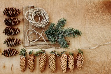 Çam kozalakları ve Kraft kağıt ahşap arka plan üzerinde. Noel hediyeleri el yapımı oluşturma kavramı