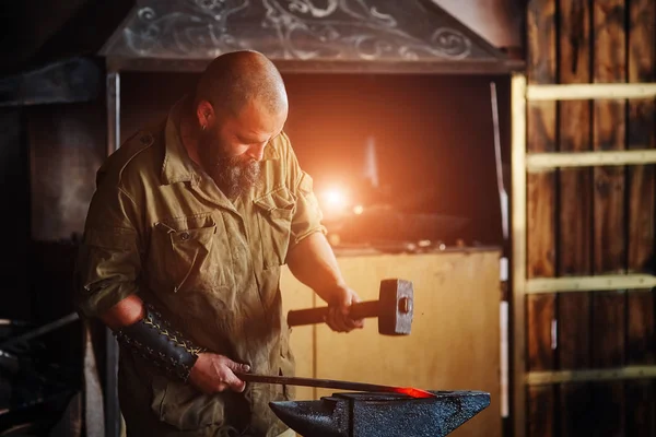 Forgeron travaillant dans la forge. Fabrication de pièces et d'armes en métal fondu, à l'aide du marteau et de l'enclume . — Photo