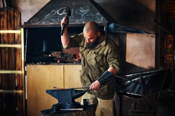 Kovács dolgozik a kovácsolni. Alkatrész gyártása fegyver olvadt fém, Üllő és kalapács. — Stock Fotó