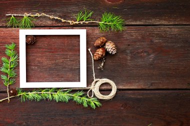Noel ahşap arka plan. Çam dalları ve koniler ile boşaltmak için beyaz çerçeve.