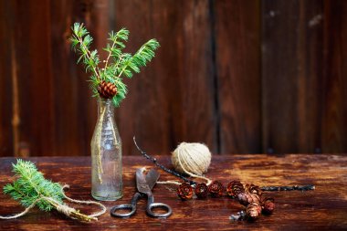 Noel ahşap arka plan. Çam dalları ve koniler vintage bir şişe, eski makas ve kurnaz kordon. Eğitim kavramı Noel için ayarlar. 