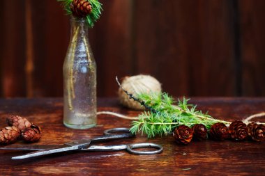 Noel ahşap arka plan. Çam dalları ve koniler vintage bir şişe, eski makas ve kurnaz kordon. Eğitim kavramı Noel için ayarlar. 