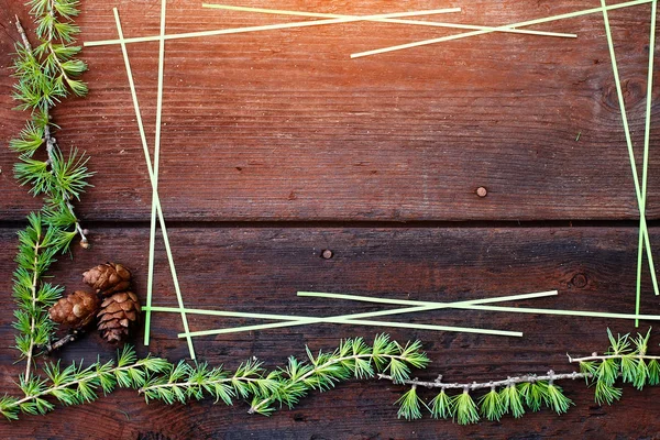 Christmas trä bakgrund. FIR tree grenar med fir kottar. Ovanifrån. Kopiera utrymme. — Stockfoto