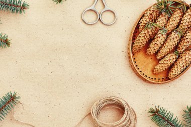 El yapımı yılbaşı hediyeleri ve onlar için arka plan Kraft kağıt, makas, çam kozalakları ve jüt Kordon üzerinde gerekli her şey. Üstten Görünüm. Sadelik kavramı