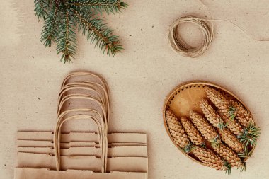 El yapımı hediyeler Noel ve onlar için ihtiyacın olan her şey. Kraft kağıt, çam dalları ve jüt kordon çanta. Üstten Görünüm, sadelik ve minimalizm kavramı