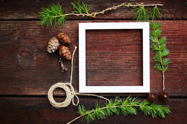 Noel ahşap arka plan. Çam dalları ve koniler ile boşaltmak için beyaz çerçeve.