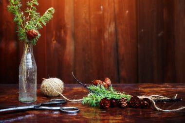 Noel ahşap arka plan. Çam dalları ve koniler vintage bir şişe, eski makas ve kurnaz kordon. Eğitim kavramı Noel için ayarlar. 