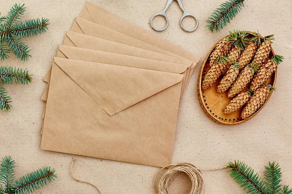 Noel hediyeleri ve harfler el yapımı ve onlar için gerekli her şey. Zarf Kraft kağıt, makas, çam kozalakları ve jüt kordon. Üstten Görünüm. Sadelik kavramı