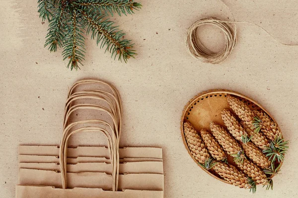 El yapımı hediyeler Noel ve onlar için ihtiyacın olan her şey. Kraft kağıt, çam dalları ve jüt kordon çanta. Üstten Görünüm, sadelik ve minimalizm kavramı