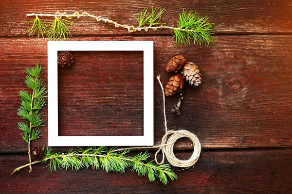 Noel ahşap arka plan. Çam dalları ve koniler ile boşaltmak için beyaz çerçeve.