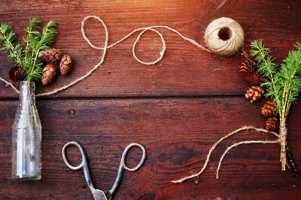 Christmas trä bakgrund. Spruce grenar och kottar i en vintage flaska, gamla sax och listig sladd. Begreppet träning anger för jul. Ovanifrån. — Stockfoto