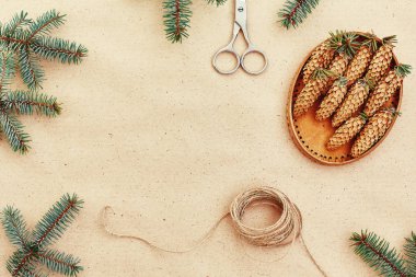 El yapımı yılbaşı hediyeleri ve onlar için arka plan Kraft kağıt, makas, çam kozalakları ve jüt Kordon üzerinde gerekli her şey. Üstten Görünüm. Sadelik kavramı