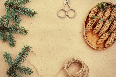El yapımı yılbaşı hediyeleri ve onlar için arka plan Kraft kağıt, makas, çam kozalakları ve jüt Kordon üzerinde gerekli her şey. Üstten Görünüm. Sadelik kavramı