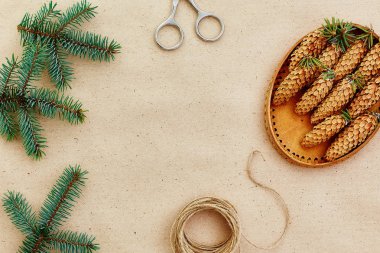El yapımı yılbaşı hediyeleri ve onlar için arka plan Kraft kağıt, makas, çam kozalakları ve jüt Kordon üzerinde gerekli her şey. Üstten Görünüm. Sadelik kavramı