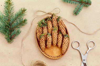 El yapımı yılbaşı hediyeleri ve onlar için arka plan Kraft kağıt, makas, çam kozalakları ve jüt Kordon üzerinde gerekli her şey. Üstten Görünüm. Sadelik kavramı