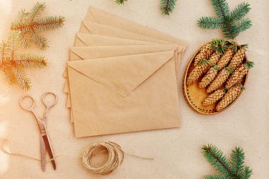 Noel hediyeleri ve harfler el yapımı ve onlar için gerekli her şey. Zarf Kraft kağıt, makas, çam kozalakları ve jüt kordon. Üstten Görünüm. Sadelik kavramı
