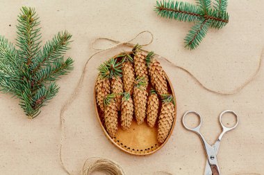 El yapımı yılbaşı hediyeleri ve onlar için arka plan Kraft kağıt, makas, çam kozalakları ve jüt Kordon üzerinde gerekli her şey. Üstten Görünüm. Sadelik kavramı