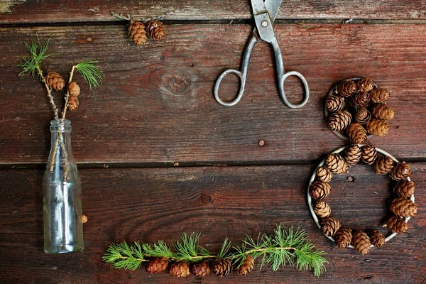 Fundo de Natal em velhas tábuas de madeira com elemento decorativo na forma de uma figura oito, tesoura antiga, garrafa antiga e cones — Fotografia de Stock