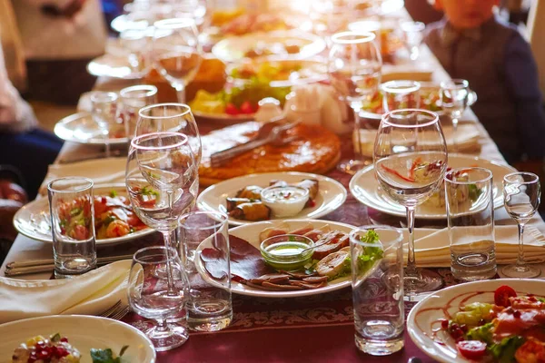 Um grupo de pessoas a uma mesa longa com comida. O conceito para a celebração conjunta de datas ou feriados memoráveis — Fotografia de Stock