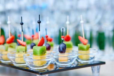 Farklı peynir, kivi, ananas, çilek ve üzümlerden oluşan cam tepsi. Yemeklerin güzel sunumu, yemek servisi..