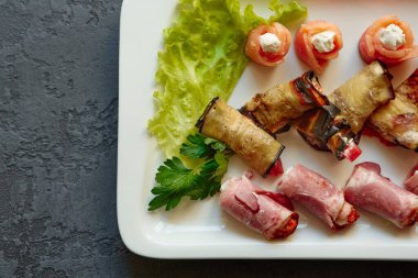 Açık büfe ve şenlik masası için farklı dolgulu küçük somon, patlıcan ve jambonlu bir tabak..