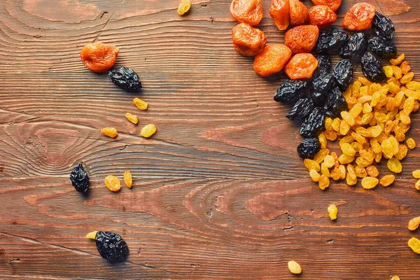 Mix dried fruits collection. On a wooden background. Dried fruits are stored without a refrigerator for a long time.