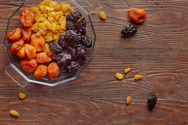Close-up of mixed dried fruits - dried apricot, prunes and grapes. The concept of long-term storage of food stocks without a refrigerator.