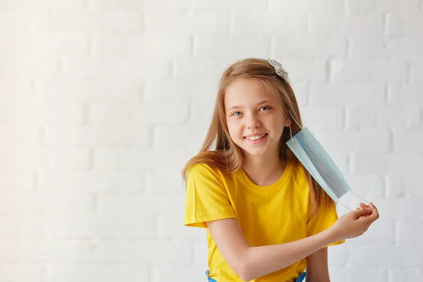 Uma Menina Sorridente Feliz Remove Sua Máscara Médica Estéril Protetora — Fotografia de Stock