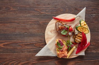 Tahta bir tahtanın üzerinde balık, et, sebze ve peynirle çeşitlendirilir. Yukarıdan görüntü, mesaj için yer. Geleneksel İtalyan aperatifi veya aperatifi, antipasto.