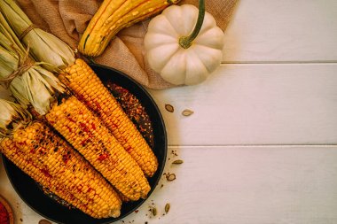 Koçanda lezzetli altın ızgara mısır bir baharat ve taze çiftlik sebze ile ahşap vintage tahta üzerinde barbekü ızgara servis. Organik, biyo gıda.